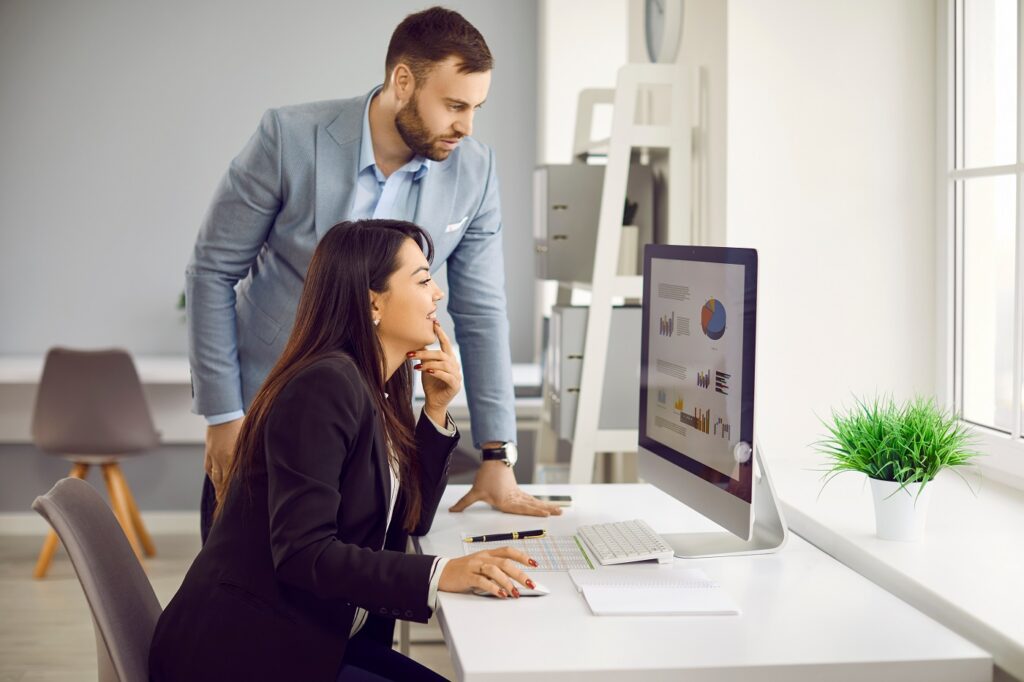 Woman and man looking at digital screen for finance work